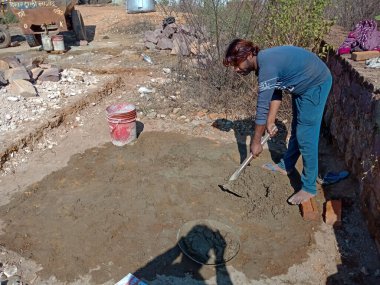 DISTRICT KATNI, Hindistan - 13 Aralık 2019: İnşaat alanında inşaat malzemesi yapmak için çimentoyla suyu karıştıran bir Hint köyü işçiliği.
