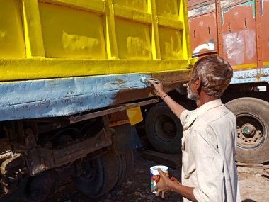 DISTRICT KATNI, Hindistan - 14 Aralık 2019: Açık otomobil garajında kamyonet gövdesine mavi renk uygulayan Hintli bir ressam.