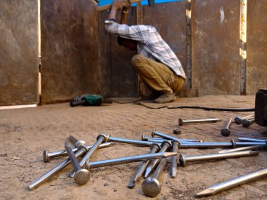 DİSTRİK KATNI, INDIA - 14 Aralık 2019: Garajdaki kamyon kabin demir yüzey arka planında çiviler mekanik çekiçle çakılmaya devam edildi.