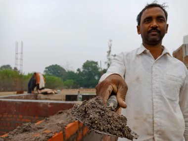 DISTRICT KATNI, INDIA - 18 Aralık 2019: Bir Hint köyü erkek işçisinin ev inşaatında güçlendirilmiş yapı malzemeleri sunması.