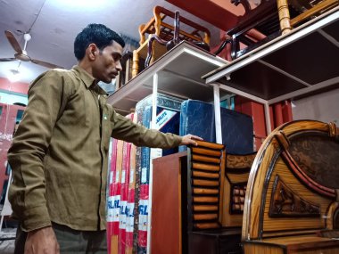 DISTRICT KATNI, INDIA - HAZİRAN 08, 2020: Hintli bir erkek esnaf mobilya mağazasında çift kişilik yatak sergiledi.