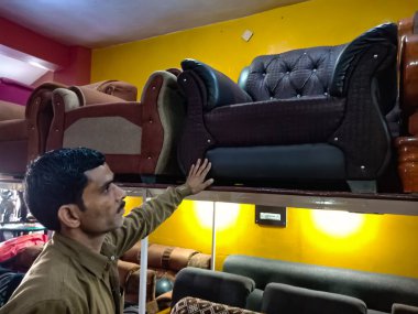 DISTRICT KATNI, INDIA - HAZİRAN 08, 2020: Hintli bir erkek esnaf mobilya mağazasında kanepe sergilendi.