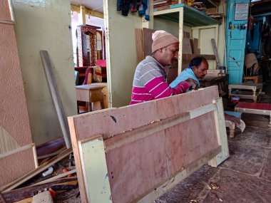 DİSTRİK KATNI, Hindistan - 08 Ocak 2020: Asyalı bir erkek marangoz atölyede mobilya yatağı yapıyor.