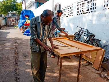 DISTRICT KATNI, Hindistan - 08 Ocak 2020: Hintli yaşlı bir marangoz açık alan atölyesinde ahşap kapı yapıyor.