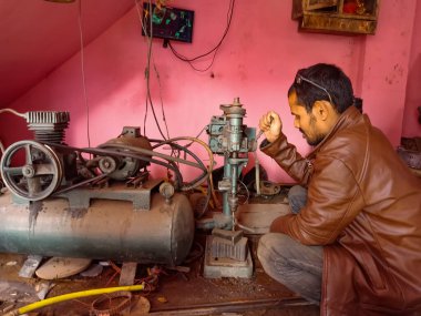 DISTRICT KATNI, INDIA - 08 HAZİRAN 2020: Bir Hintli fabrika işçisi atölyede gaz kaynak makinesi tutuyordu.