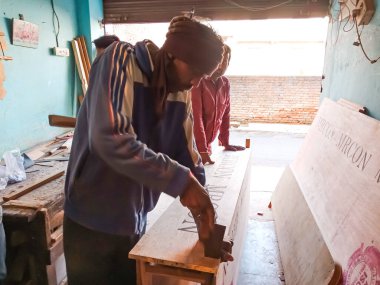 DISTRICT KATNI, INDIA - HAZİRAN 08, 2020: Ahşap atölyesi için sıvı fevicol uygulayan Hintli bir marangoz.