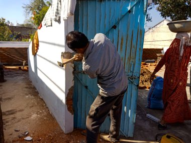 DİSTRİK KATNI, Hindistan - 13 Ocak 2020: Hintli bir inşaat işçisi duvara çekiçle vurdu.