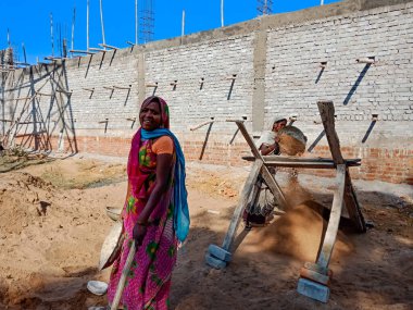 DISTRICT KATNI, INDIA - 18 HAZİRAN 2020: Hindistan köyü bayanları gökyüzü arka planındaki inşaat alanında birlikte çalışıyorlar.