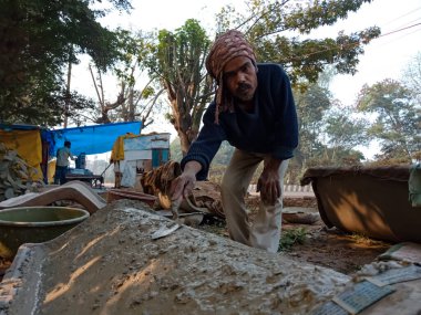 DISTRICT KATNI, INDIA - 18 HAZİRAN 2020: Doğal arka planda açık alan atölyesine park sandalyesi yapmak için çimento sıva yapan bir Hint işçiliği.