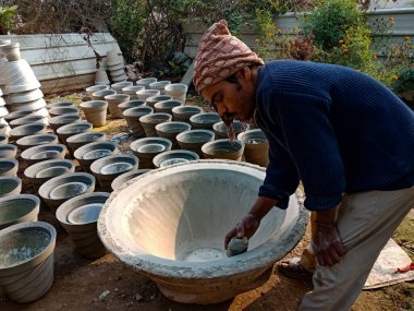 DISTRICT KATNI, INDIA - 18 Ocak 2020: Hintli bir sanatçı doğal arka plandaki açık alan atölyesinde çimento tenceresi inşa etmeyi bitirdi.
