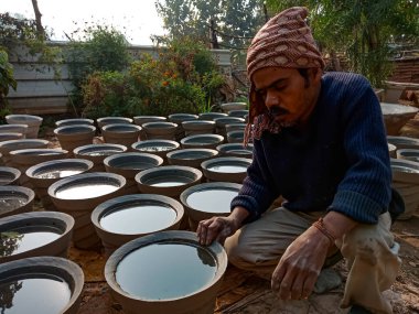 DISTRICT KATNI, INDIA - 18 HAZİRAN 2020: Doğal arka plandaki açık alan atölyesine çimento döşeyen Hintli bir sanatçı.