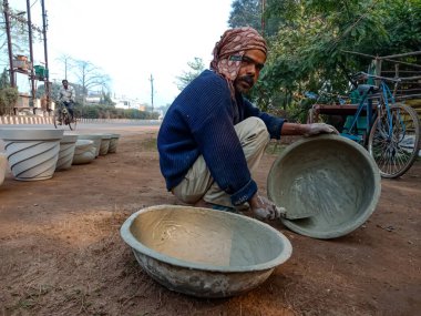 DISTRICT KATNI, INDIA - 18 HAZİRAN 2020: Doğal arka plandaki inşaat sahasında çimento temizliği yapan Hintli bir işçi.