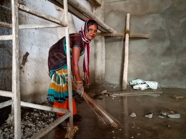 DISTRICT KATNI, INDIA - 18 OCAK 2020: İnşaat alanındaki su tabanını temizleyen Hintli bir kadın işçi.