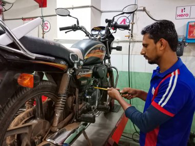DISTRICT KATNI, INDIA - 18 HAZİRAN 2020: Hero motosiklet atölyesinde motor tamir eden Hintli otomobil mühendisi.