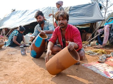 DISTRICT KATNI, INDIA - 21 HAZİRAN 2020: Hintli yoksul köylü sanatçı açık alan atölyesindeki toprak sahada müzikal davul üssü oluşturdu.