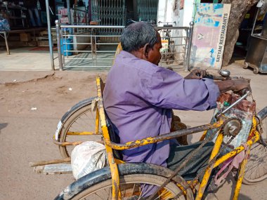 DISTRICT KATNI, INDIA - 19 HAZİRAN 2020: Engelli bisikletinden yol kenarına Hintli yaşlı bir adam nakliyesi.