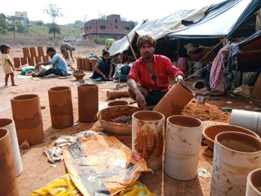 DISTRICT KATNI, INDIA - 21 HAZİRAN 2020: Hintli yoksul köylü sanatçı açık alan atölyesindeki toprak sahada müzikal davul üssü oluşturdu.
