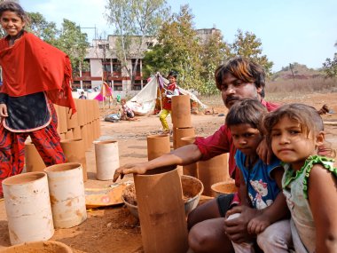 DISTRICT KATNI, INDIA - 21 HAZİRAN 2020: Hindistan 'ın fakir sanatçısı çocuklarla birlikte açık alan atölyesinde oturuyor.