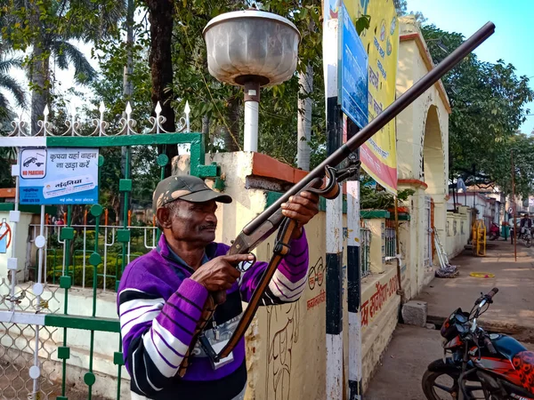 DISTRICT KATNI, INDIA - 18 HAZİRAN 2020: Hintli bir köy güvenlik görevlisi mavi gökyüzü arka planında bir tüfek tutuyordu.