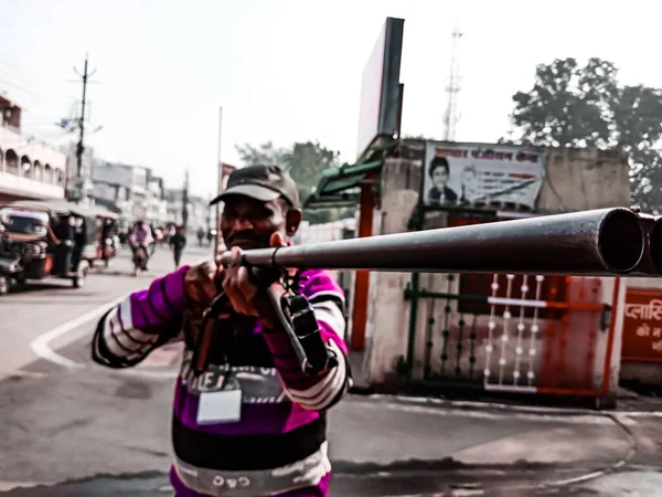 DISTRICT KATNI, INDIA - 18 HAZİRAN 2020: Hintli bir güvenlik görevlisi kameraya tüfek doğrultuyor, mavi gökyüzü arka planında seçici bir yakın plan.