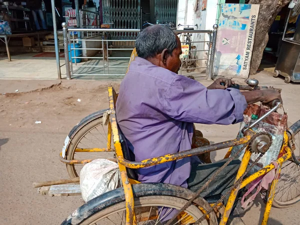 DISTRICT KATNI, INDIA - 19 HAZİRAN 2020: Engelli bisikletinden yol kenarına Hintli yaşlı bir adam nakliyesi.