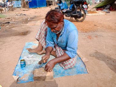 DISTRICT KATNI, INDIA - 21 HAZİRAN 2020: Hintli fakir sanatçı açık alan atölyesinde el işi yapıyor.