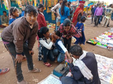 DISTRICT KATNI, INDIA - 21 HAZİRAN 2020: Festival programında dövmeler yapan Hintli yoksul sanatçı.