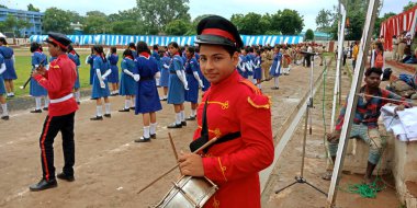 DISTRICT KATNI, INDIA - 15 Ağustos 2019: Bağımsızlık Günü etkinlikleri için şehir parkında çubuklarla davul çalan Hintli bir izci çocuk.