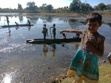 KITY KATNI, INDIA - 03 ARALIK 2019: Fakir bir Hint köyü kızı su gölünü doğal ortamda işaret ediyor.