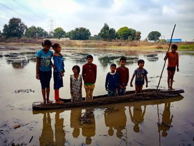DİSTRİK KATNI, INDIA - HAZİRAN 01, 2020: Asyalı köy balıkçıları akşam vakti su gölünde kayıkla geziyorlar.