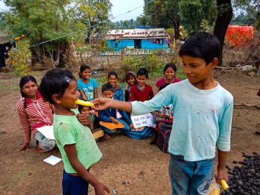 DİSTRİK KATNI, INDIA - HAZİRAN 01, 2020: Hintli çocuk köy çevresindeki kıza yiyecek sağlıyor.