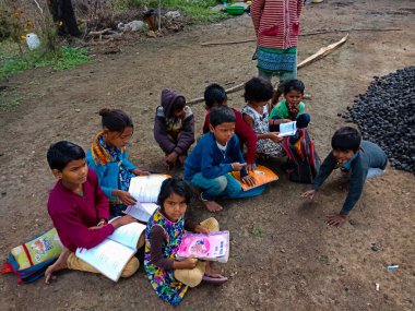 DISTRICT KATNI, INDIA - HAZİRAN 01, 2020: Asyalı yoksul çiftçi çocuklar köy eğitimi sırasında açık toprak arka planında birlikte öğreniyorlar.