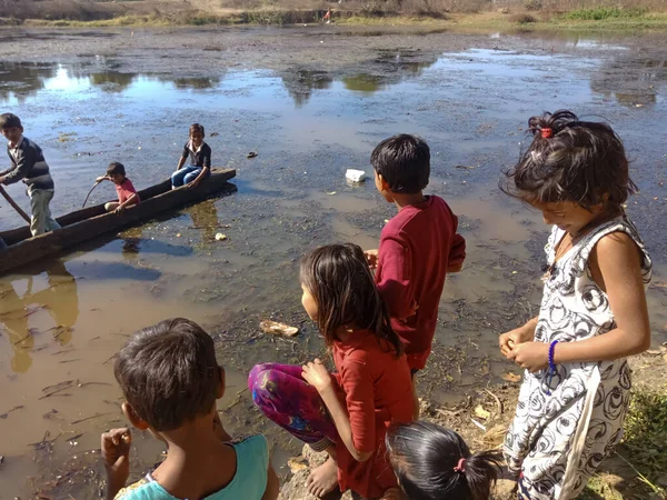 KITY KATNI, INDIA - 3 ARALIK 2019: Doğal ortamda su gölü etrafında oynayan fakir Hint köyü çocukları.