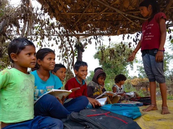 DISTRICT KATNI, INDIA - HAZİRAN 01, 2020: Bir Hint devlet okulu fakir kız çocuğu köy açık hava ortamında çocuklara öğretmenlik yapıyor.