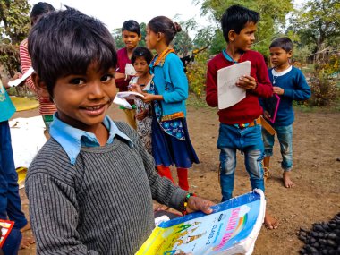 DISTRICT KATNI, INDIA - HAZİRAN 01, 2020: Asyalı yoksul çiftçi çocuklar köy eğitimi sırasında açık toprak arka planında birlikte öğreniyorlar.