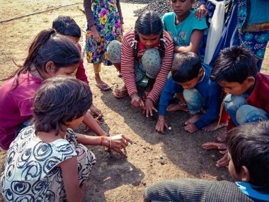 DISTRICT KATNI, INDIA - HAZİRAN 01, 2020: Asyalı fakir köy çocukları taze ve sağlıklı kırsal çevrede golf oynuyorlar.