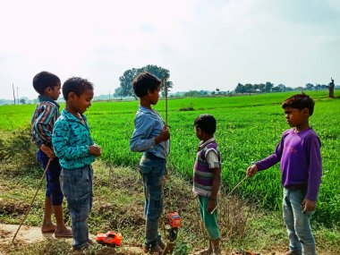 DISTRICT KATNI, INDIA - HAZİRAN 01, 2020: Kırsal alanda oyuncak arabalarla oynayan Asyalı fakir köy çocukları grubu.