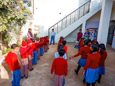 DİSTRİK KATNI, INDIA - 13 Ocak 2020: Hintli ilkokul öğrencileri grubu açık arkaplanda toplanıyor kırmızı renk üniforması giyiyorlar.
