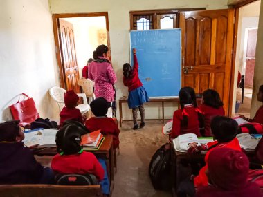 DİSTRİK KATNI, Hindistan - 13 HAZİRAN 2020: Hindistan köyü çocuğu sınıftaki ahşap bankta okuyor.