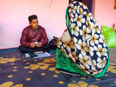DISTRICT KATNI, INDIA - 16 HAZİRAN 2020: Mikro finansman kredisi ödemesi için oturan Hintli köy kadınları, küçük grup toplantısı programı.
