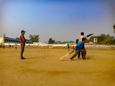 DİSTRİK KATNI, INDIA - 02 Aralık 2019: Hintli şehir insanları güzel gökyüzü alanı etrafında ormanlarda kriket oynuyorlar.