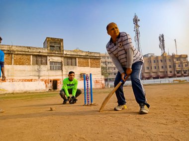 DİSTRİK KATNI, INDIA - 02 Aralık 2019: Hintli şehir insanları güzel gökyüzü alanı etrafında ormanlarda kriket oynuyorlar.