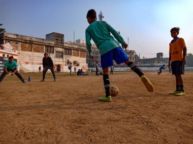 DİSTRİK KATNI, INDIA - 02 Aralık 2019: Hintli şehirli çocuklar güzel gökyüzü sahasının etrafındaki parkta birlikte futbol oynuyorlar.