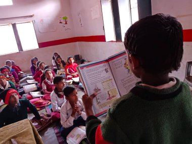 DİSTRİK KATNI, Hindistan - 21 HAZİRAN 2020: Hindistan devlet okulu öğrencisi sınıfta ders kitabı okuyor.