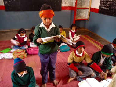 DISTRICT KATNI, Hindistan - 21 HAZİRAN 2020: Hindistan devlet okulu çocuğu sınıfta sübjektif ders kitabı okuyor.