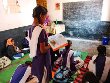 DİSTRİK KATNI, Hindistan - 21 HAZİRAN 2020: Hindistan devlet okulu öğrencisi sınıf ders kitabı okuyor.