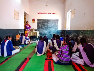 DİSTRİK KATNI, INDIA - 21 HAZİRAN 2020: Hindistan devlet okulu kız öğrencileri sınıfta birlikte oturuyorlar.