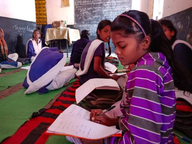 DİSTRİK KATNI, Hindistan - 21 HAZİRAN 2020: Hindistan devlet okulu kız öğrencisi sınıfta sübjektif ders kitabı okuyor.