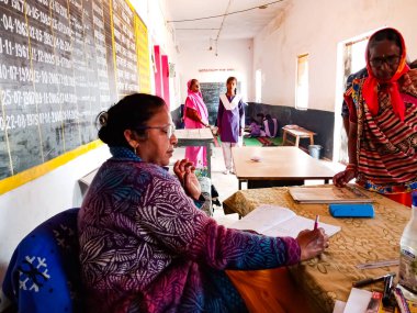 DISTRICT KATNI, INDIA - 21 HAZİRAN 2020: Hindistan devlet okulu müdürü ofis masasındaki defterde yazıyor.