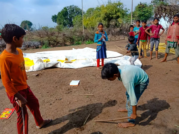 DISTRICT KATNI, INDIA - HAZİRAN 01, 2020: Asyalı fakir köy çocukları taze ve sağlıklı kırsal çevrede gilli danda oynuyorlar.